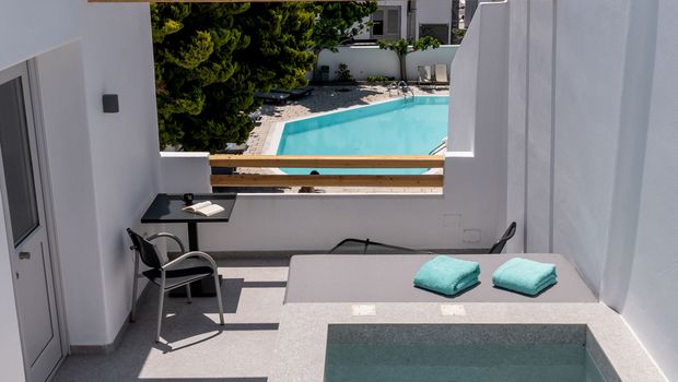 Private Terrasse mit Pool, Sonnenliege und Sitzgelegenheit – Blick auf den gemeinschaftlichen Pool und die umliegende Berglandschaft für entspannte Urlaubsmomente in ruhiger Atmosphäre.
