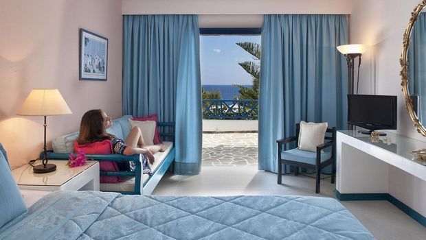 Helles Zimmer mit gemütlicher Sitzecke, großem Bett und traumhaftem Meerblick vom eigenen Balkon – ideal zum Entspannen und Genießen.