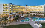 Abendaufnahme eines großen Hotels mit beleuchteten Balkonen, mehreren Restaurants und einem weitläufigen Poolbereich.