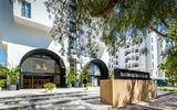 Eingangsbereich des Occidental Puerto Banús Hotels mit modernem Design, großen Glasbögen, gepflegter Begrünung und Hotelnamen auf einem stilvollen Schild.