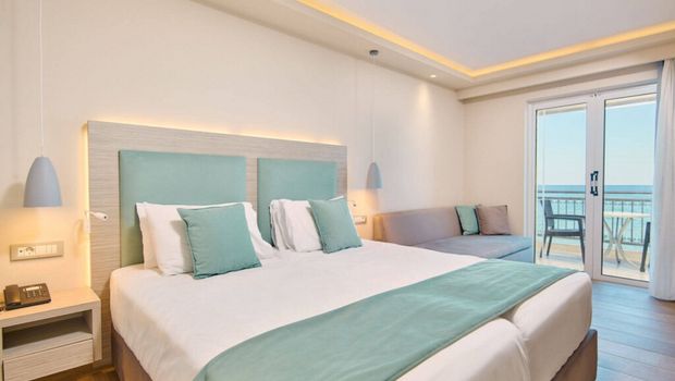 Helles, modern eingerichtetes Doppelzimmer mit eleganter Farbkombination aus Weiß und Mint sowie direktem Zugang zum Balkon mit traumhaftem Meerblick.