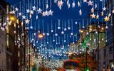 Festive Christmas decorations in the streets of London with red bus traffic during night time