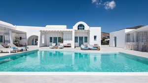 Poolansicht ©Hotel Santa Irina Luxury Sunny Lofts - momento Boutique-Hotel im kykladischen Stil mit strahlend weißer Architektur, türkisfarbenen Fensterläden und großzügigem Poolbereich – stilvolles Design in ruhiger Lage unter klarem, blauem Himmel.